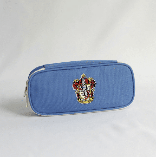 Trousse Harry Potter avec badge de Poudlard présentée en bleu sur fond blanc