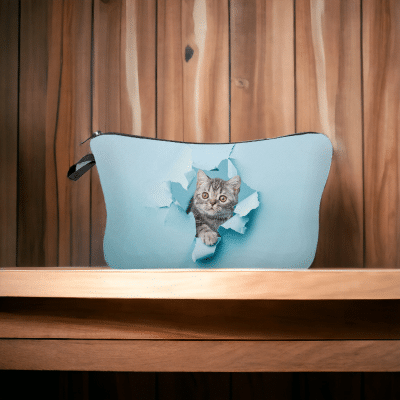 Trousse bleue avec un chaton qui sort d'un trou effet papier déchiré